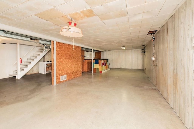 finished basement with stairway and visible vents