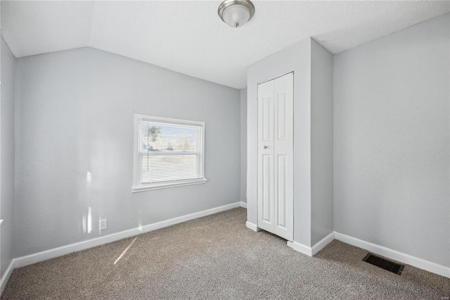 unfurnished bedroom with carpet floors, baseboards, visible vents, and a closet