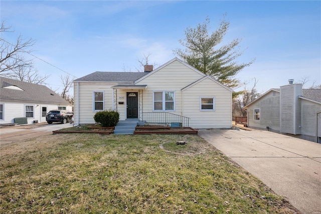 bungalow-style home featuring central AC, a chimney, and a front yard