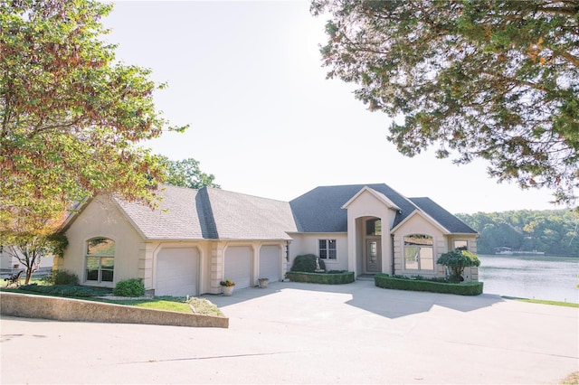 view of front facade with a garage, concrete driveway, and stucco siding