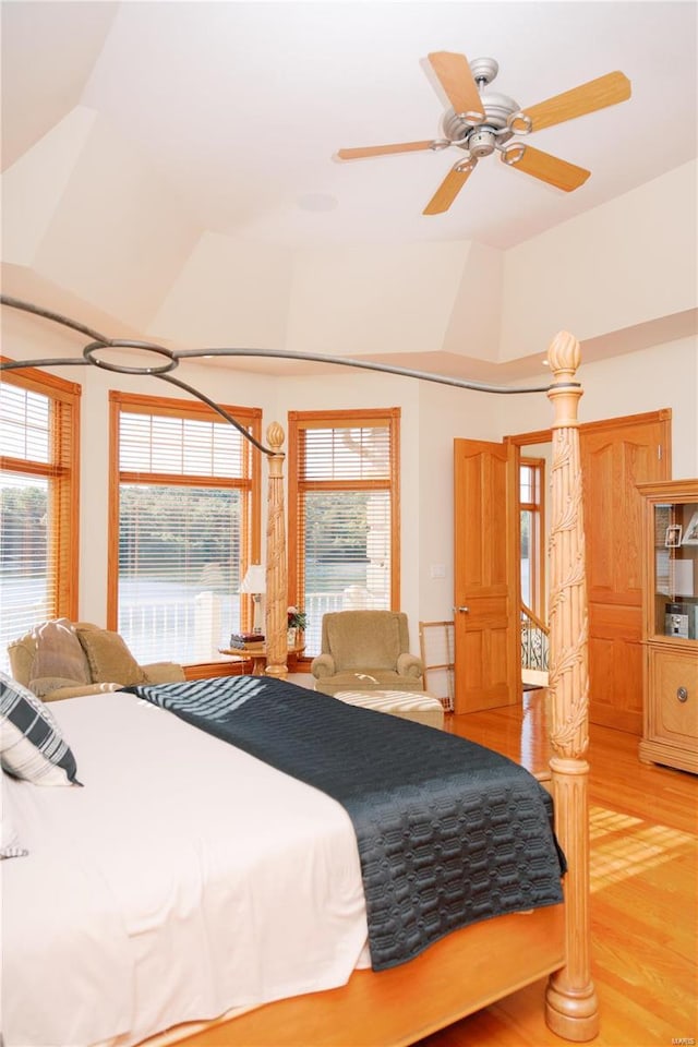 bedroom with vaulted ceiling, light wood finished floors, and ceiling fan