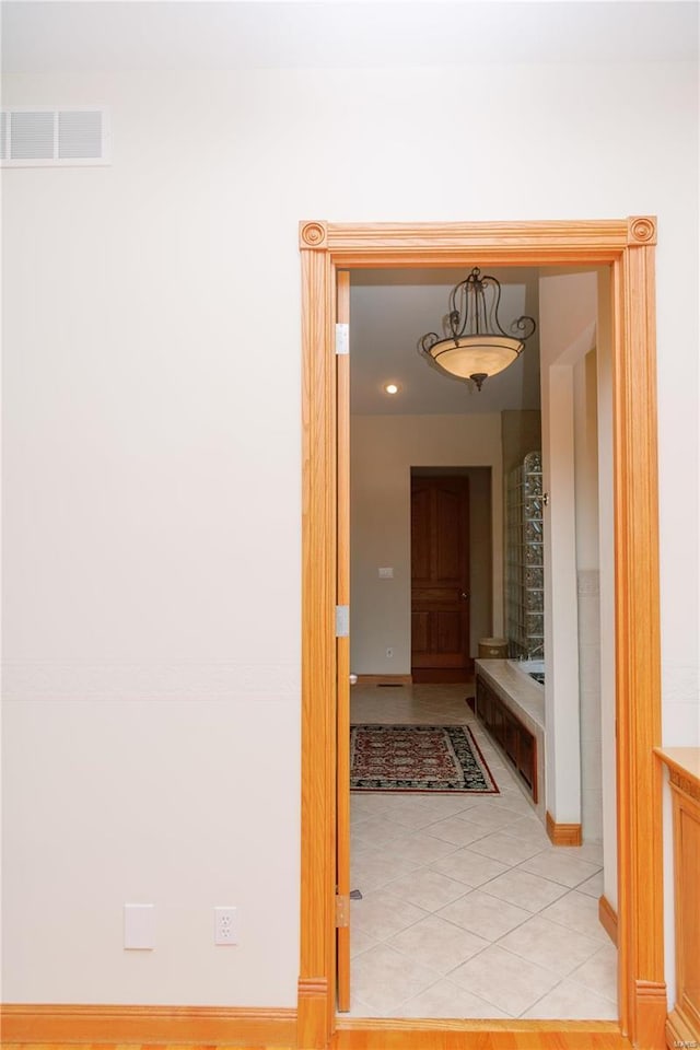 hall featuring light tile patterned floors and visible vents