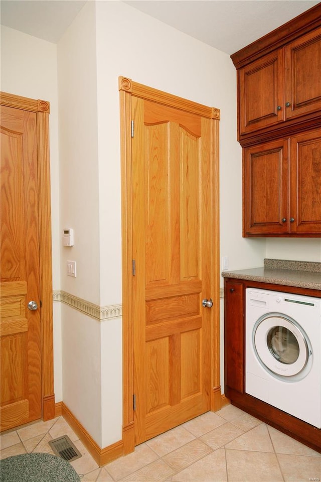 laundry area featuring washer / clothes dryer, visible vents, cabinet space, and light tile patterned flooring