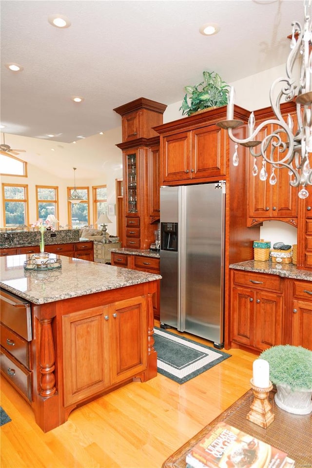 kitchen with brown cabinetry, stainless steel refrigerator with ice dispenser, and a warming drawer