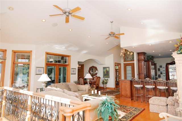 living area featuring high vaulted ceiling, light wood-type flooring, and recessed lighting