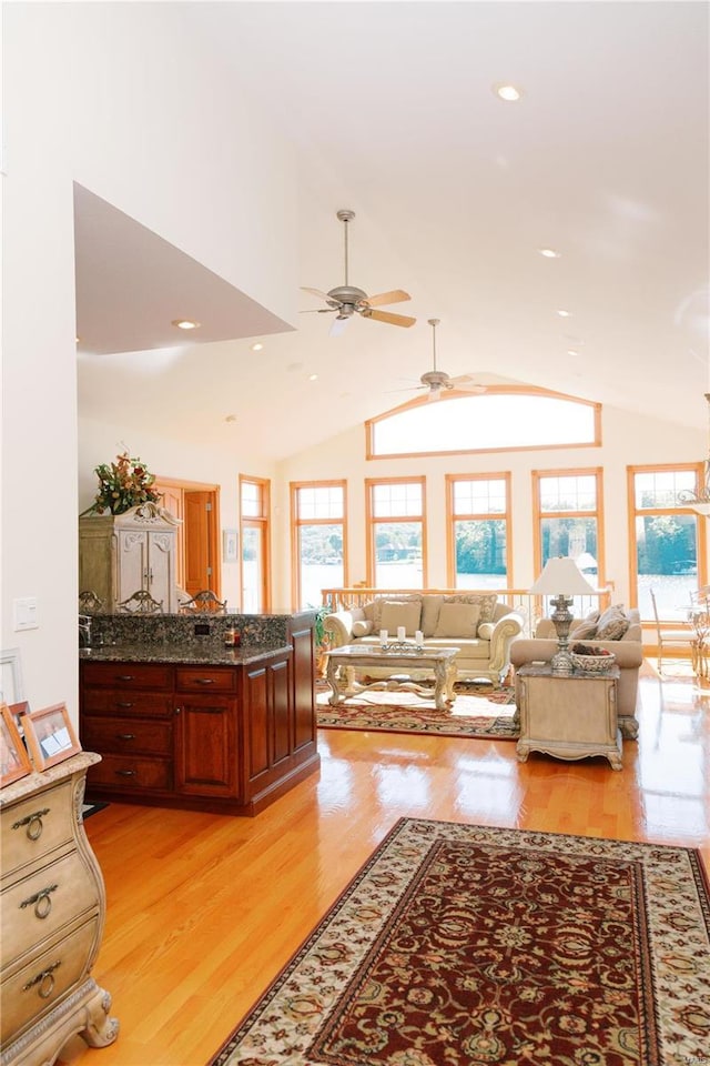 living room with vaulted ceiling, light wood finished floors, recessed lighting, and a healthy amount of sunlight