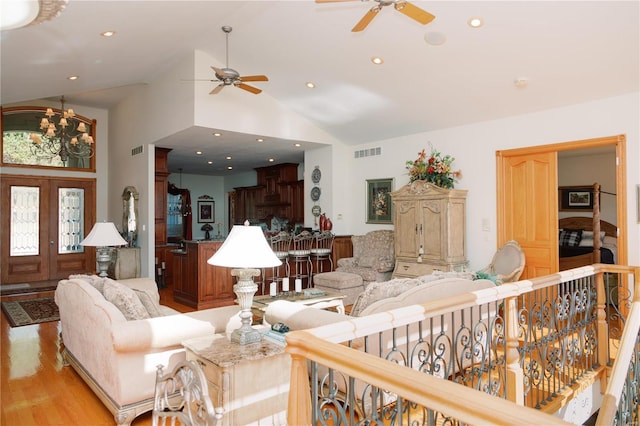 living area featuring visible vents, light wood-type flooring, high vaulted ceiling, a notable chandelier, and recessed lighting