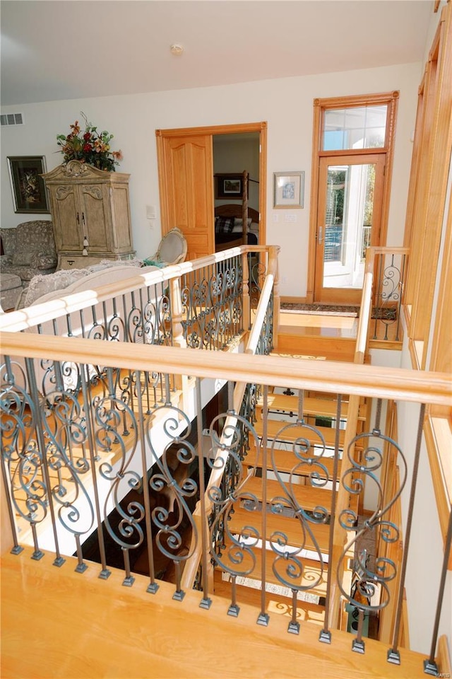 stairway with wood finished floors and visible vents