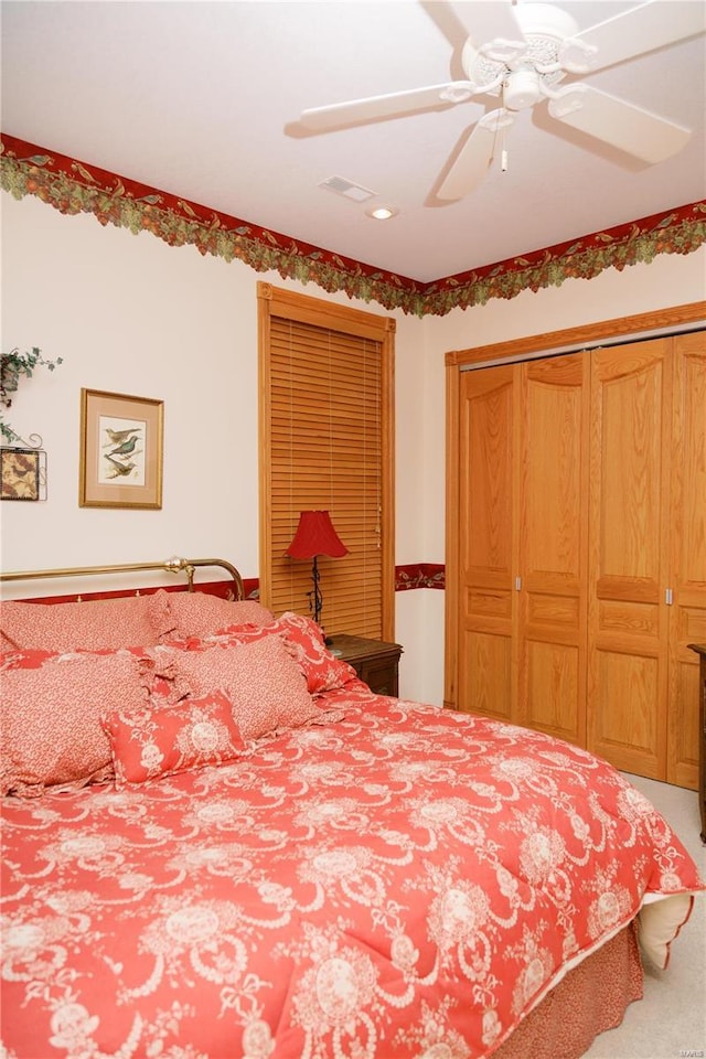 bedroom featuring a closet, carpet flooring, visible vents, and a ceiling fan