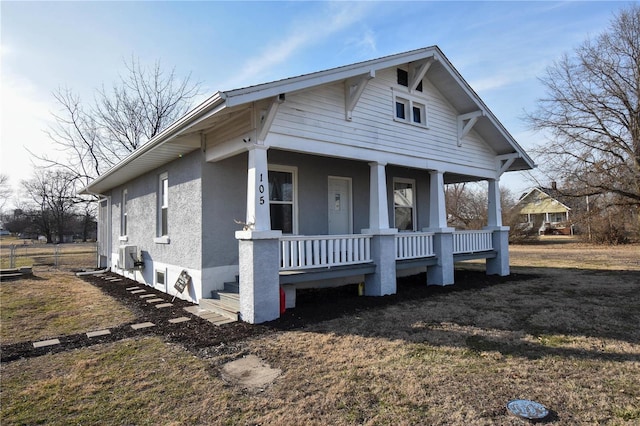 bungalow-style home with a porch and stucco siding