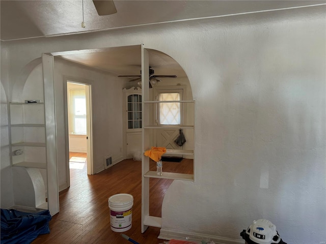 dining space with ceiling fan, arched walkways, wood finished floors, and visible vents