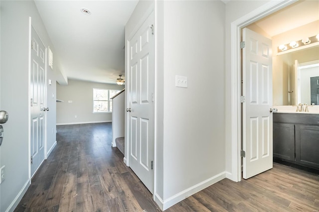 corridor featuring stairway, dark wood finished floors, and baseboards