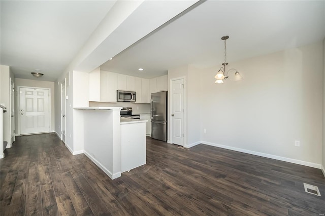 kitchen with dark wood-style floors, appliances with stainless steel finishes, visible vents, and baseboards