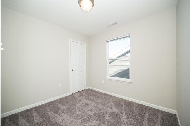 empty room with baseboards, visible vents, and carpet flooring