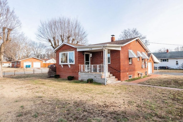 bungalow-style home featuring brick siding, a chimney, fence, a porch, and a front yard