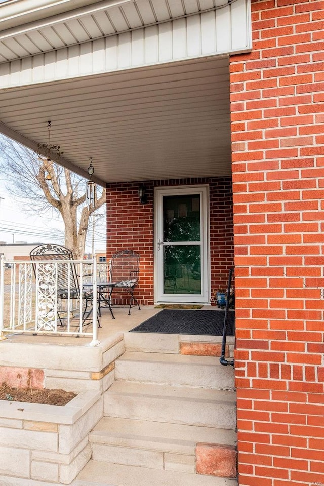 property entrance featuring brick siding