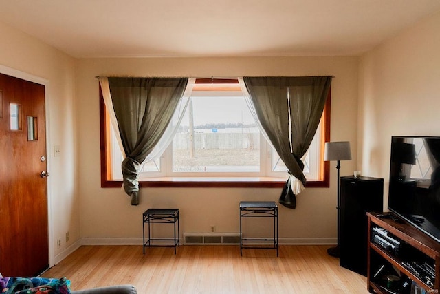 interior space featuring visible vents, light wood-style flooring, and baseboards