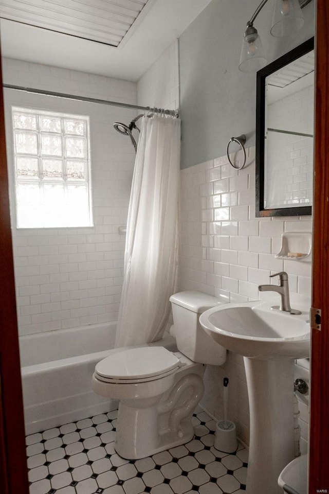 bathroom featuring toilet, shower / bath combo, and tile walls