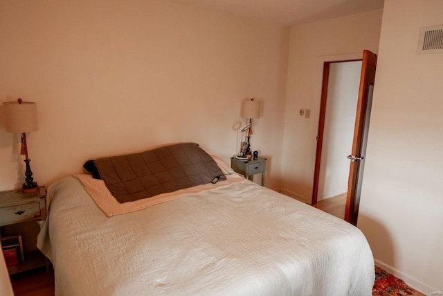 bedroom featuring baseboards and visible vents