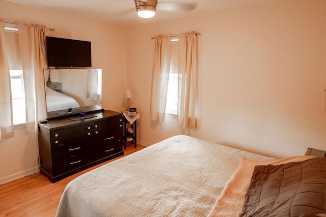 bedroom with light wood finished floors and baseboards