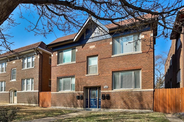 view of front facade with brick siding and fence