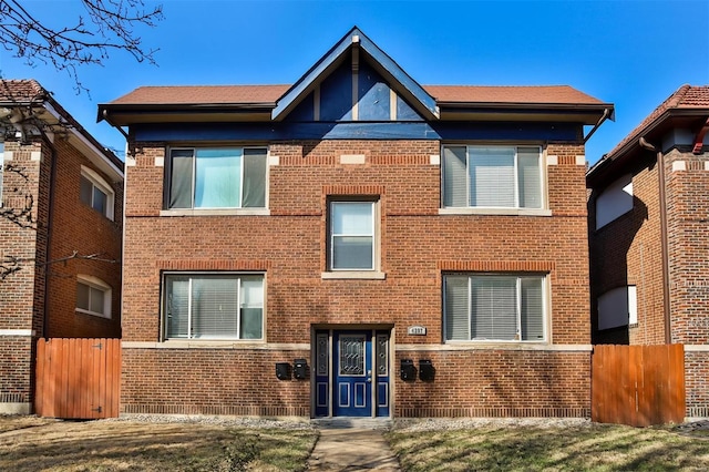 view of front facade with fence and brick siding