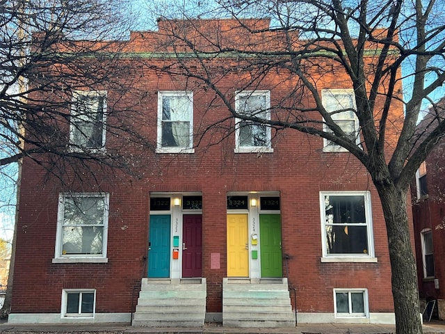 view of front of home with entry steps and brick siding