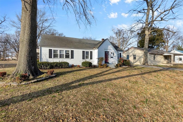 ranch-style house with a front yard and a chimney