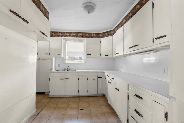 kitchen with light countertops, a sink, and white cabinets