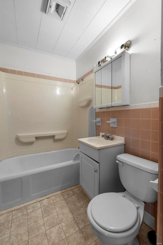 bathroom with visible vents, toilet, shower / tub combination, vanity, and tile walls