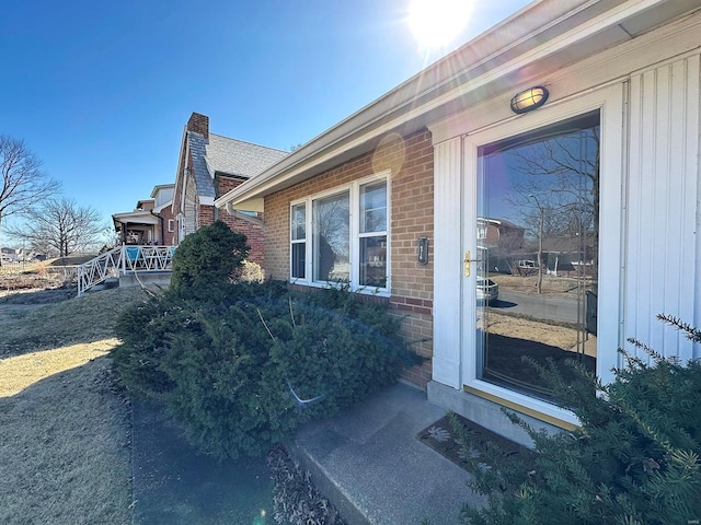 entrance to property with brick siding and a chimney