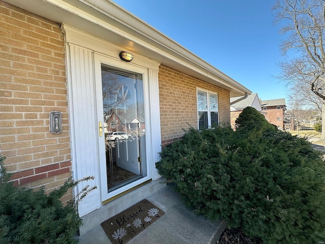 view of exterior entry featuring brick siding