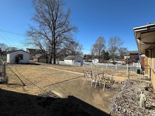 view of yard featuring outdoor dining area, an outbuilding, fence, and a patio area