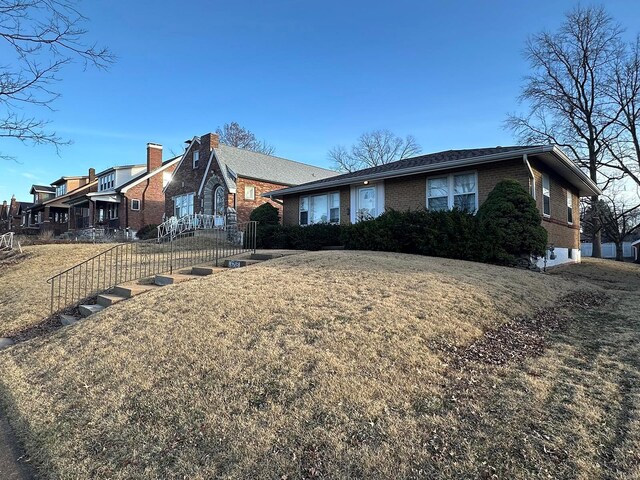 ranch-style house with a front lawn and brick siding