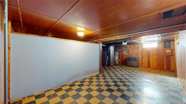 basement featuring tile patterned floors and wood walls