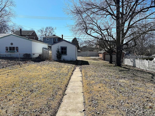 view of yard featuring an outbuilding and fence