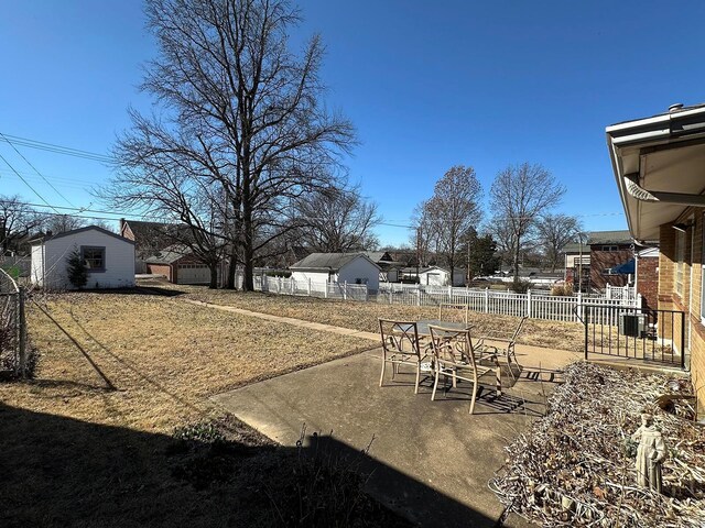 view of yard featuring outdoor dining area, an outbuilding, fence, and a patio area