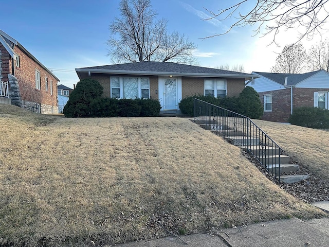 single story home with brick siding, a front lawn, and a shingled roof