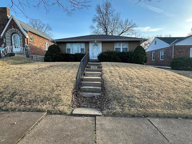 ranch-style home with brick siding and a front lawn