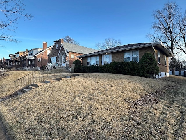 ranch-style house featuring brick siding and a front yard