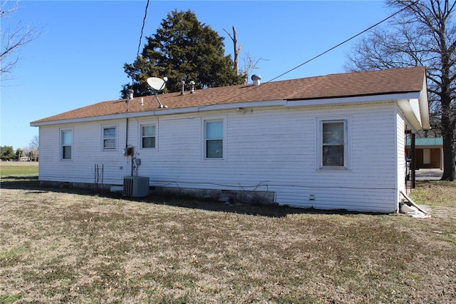 back of house featuring central AC unit and a lawn