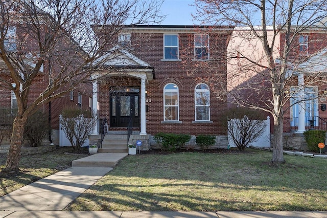 view of front of home featuring brick siding and a front lawn