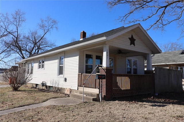 view of front of house featuring ceiling fan, a chimney, fence, and a porch