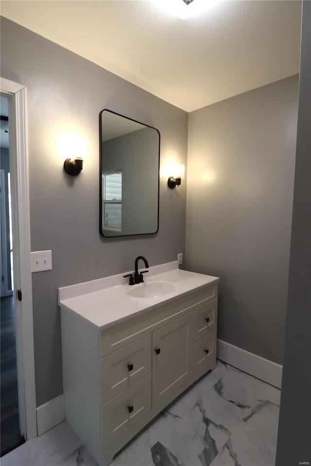 bathroom featuring marble finish floor, vanity, and baseboards