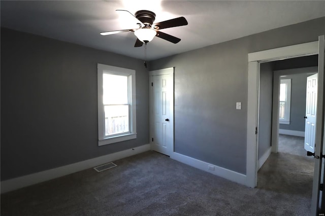 unfurnished bedroom featuring ceiling fan, carpet flooring, visible vents, baseboards, and a closet