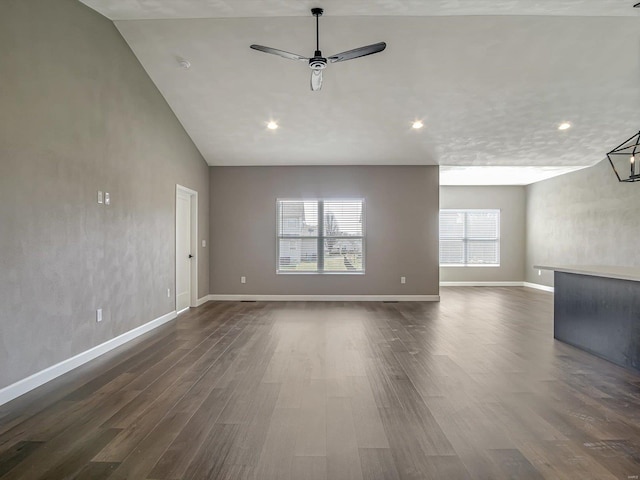 unfurnished living room with a wealth of natural light, baseboards, ceiling fan, and dark wood-style flooring