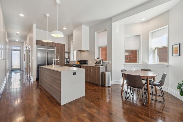 kitchen featuring stainless steel built in fridge, modern cabinets, stove, and a sink