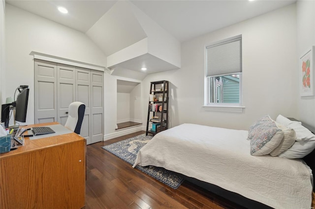 bedroom with dark wood-style floors, lofted ceiling, a closet, and recessed lighting