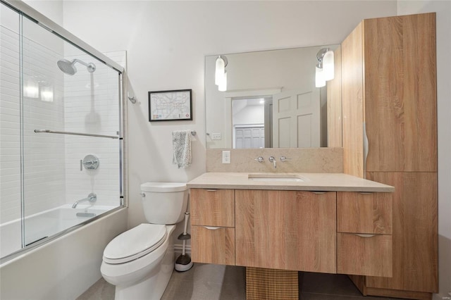 full bath featuring vanity, toilet, and bath / shower combo with glass door