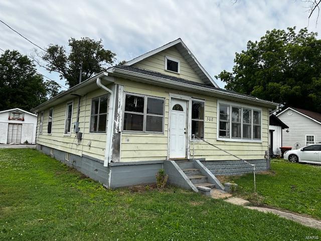 bungalow with entry steps and a front lawn